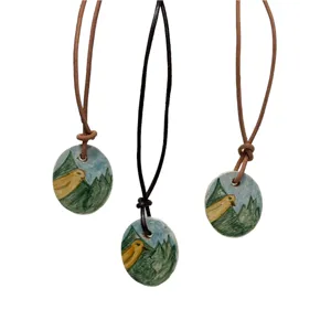 Collana con ciondolo ovale con rapace su paesaggio montano